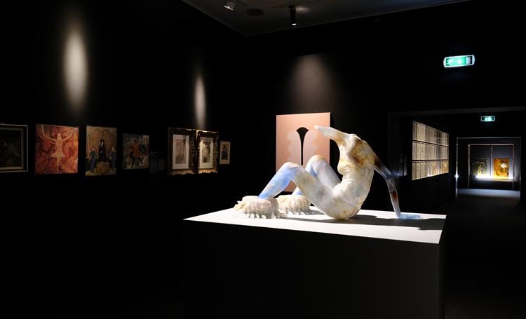 statut en marbre dans une salle noire de musée