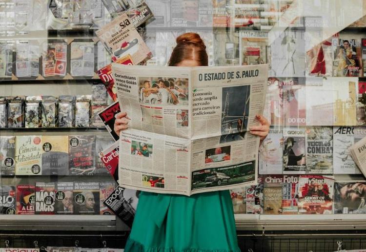 Photo d'une femme qui lis un journal