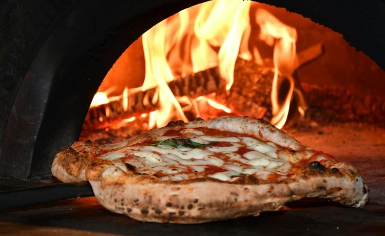 pizza devant un four à bois