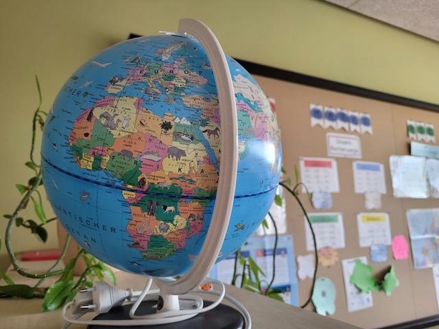 une mappemonde posée sur un bureau dans une salle de classe