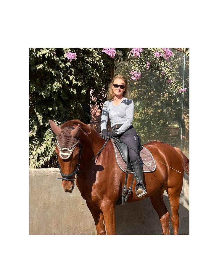 Pascale Rozier à l’écurie Black Hat Riding à Gizeh, entourée de chevaux, cavaliers et nature
