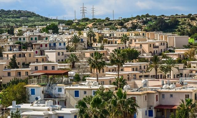 Vue d'un village cypriote en été, une forêt et des pylônes électriques étant visibles en arrière-plan