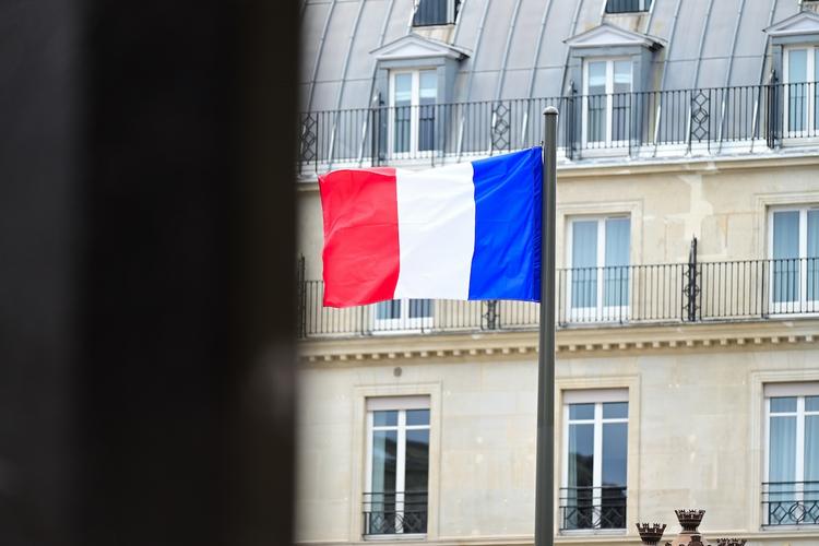 un drapeau de france qui flotte dans une ville du monde