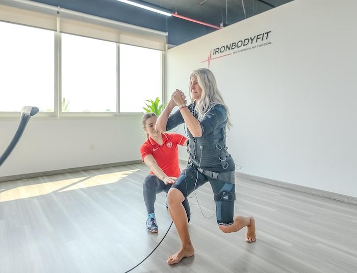 Une femme en train de faire une séance d'électro stimulation à valencia avec sa coach IronBodyfit