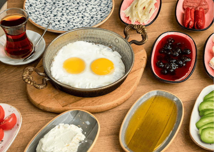 Petit-déjeuner turc traditionnel (kahvaltı) avec œufs, thé, légumes, fromage, confiture et huile d’olive – juin 2025