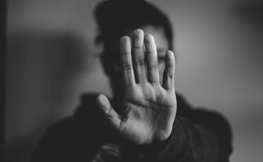 une femme lève la main devant son visage