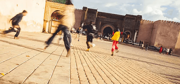 enfants qui jouent au foot dans les rues de Meknes au Marc devant bâtiments
