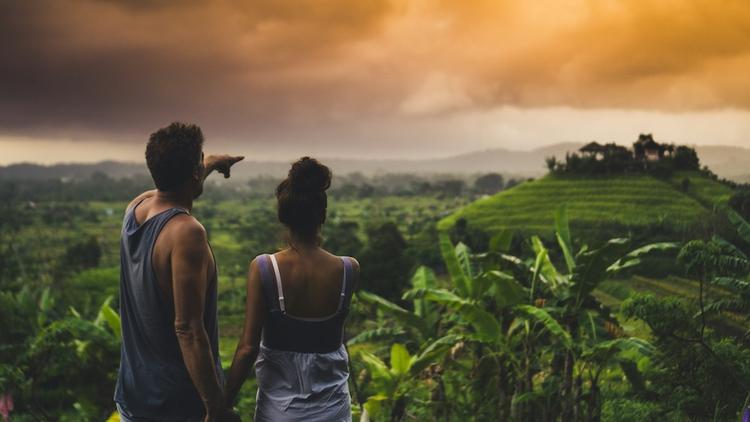 touristes à bali qui admirent la vue dans une rizière au coucher du soleil