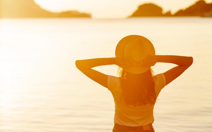 woman-with-hat-sunset-shore-lake