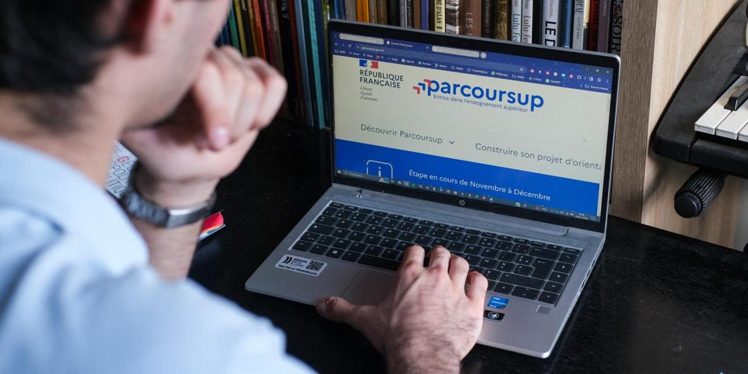 Un parent devant son écran d'ordinateur pour choisir les voeux parcoursup de son enfant expatrié