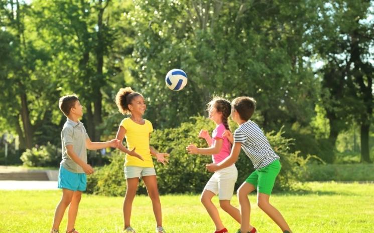 Des enfants jouent au ballon en plein-air